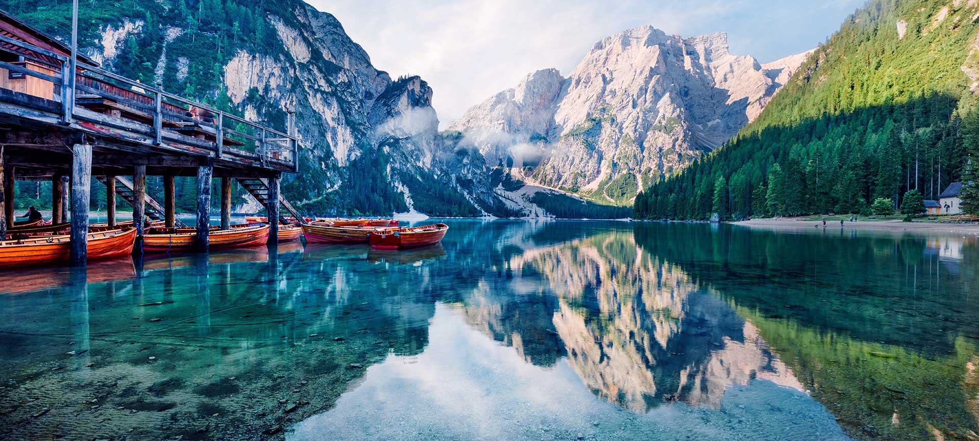Idyllische Naturkulisse am Pragser Wildsee - Karibik der Dolomiten Das berühmte Holzbootshaus am Pragser Wildsee vor der imposanten Kulisse des Seekofels bei strahlendem Sonnenschein