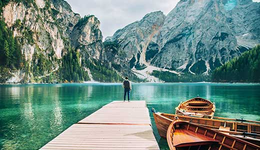 Ausblick vom Bootssteg am Pragser Wildsee Wanderer blickt vom Holzsteg des Pragser Wildsees auf das türkisblaue Wasser und den Seekofel